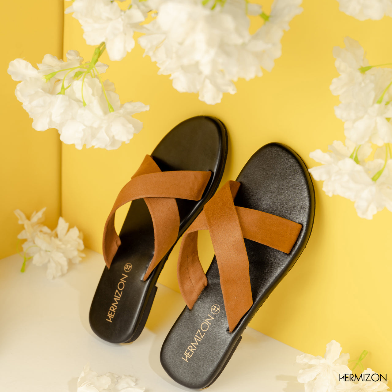 A black color sandal with brown color cross strips