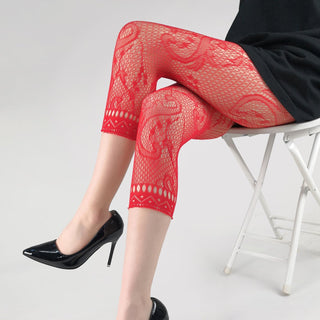 Person wearing red lace pants and black high heels on a white background