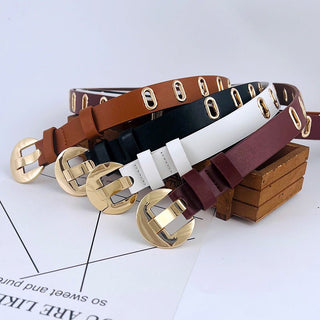 Set of belts in brown, black, white, and burgundy with gold buckles on a light gray background.
