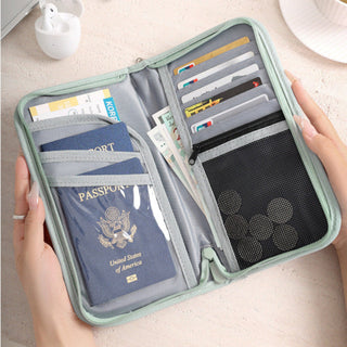 Travel organizer with passport, cards, and money held by a person.