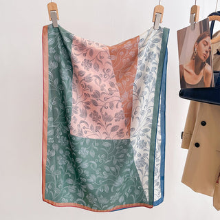 Three patterned scarves hanging on a rack with a beige coat and photo album in the background.