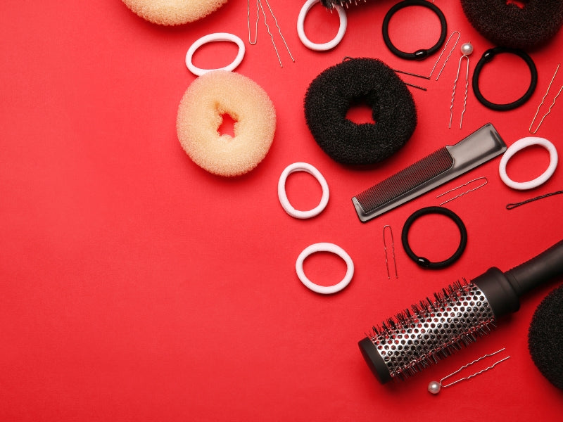 image showing different types of hair care products including hair curler, hair comb, bands, scrunches in red background.