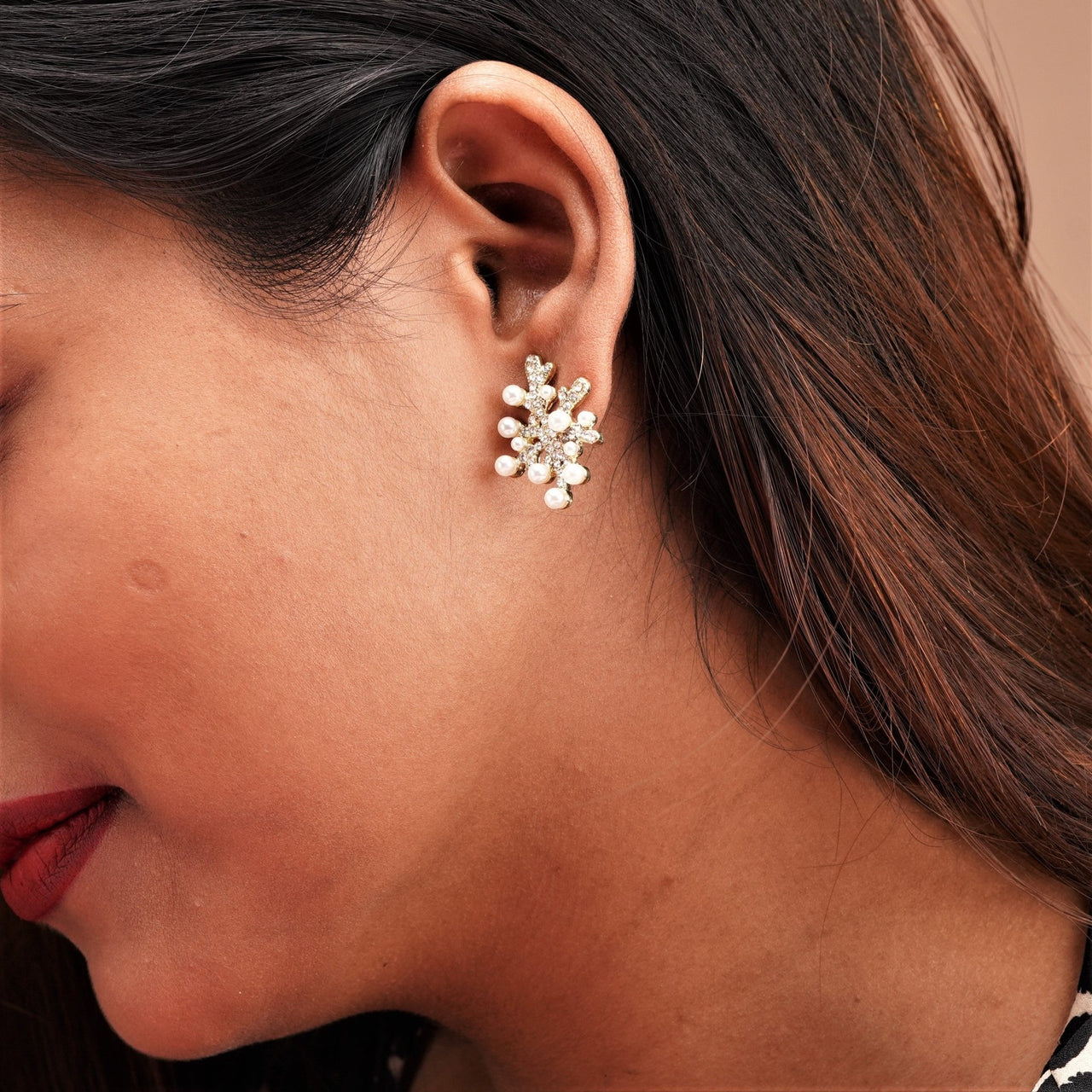 A pearl beaded design earring on a girls ear