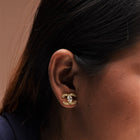 A golden color earring with stone on a girls ear