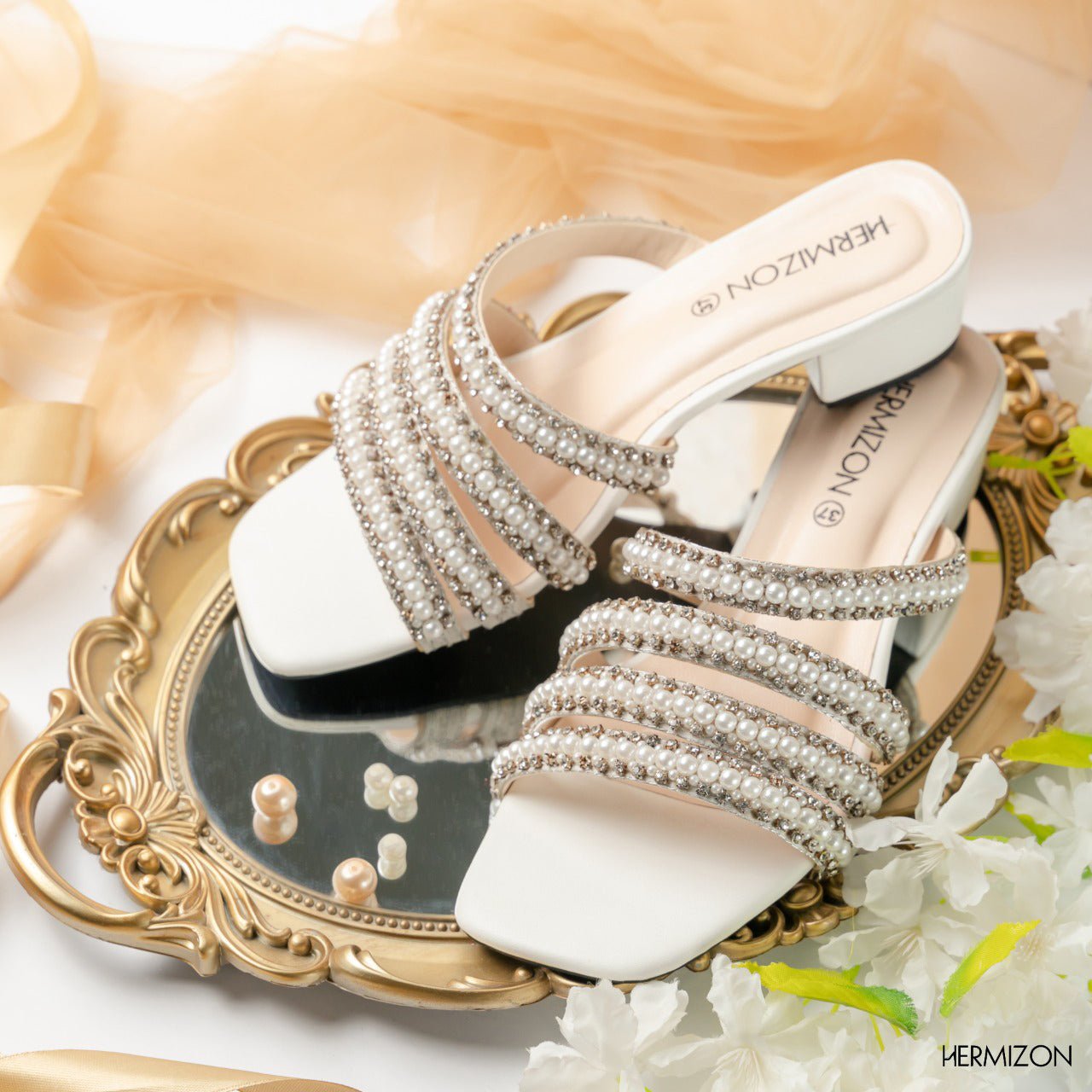 A shoe from hermizon brand which is white color and with semi heels