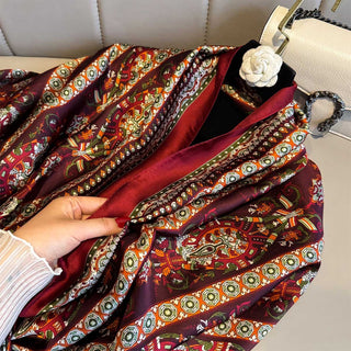 Decorative fabric with intricate patterns and a hand holding it.
