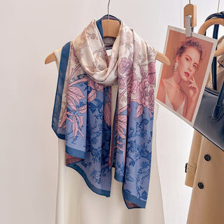 Floral patterned scarf on a mannequin with a handbag and portrait in the background