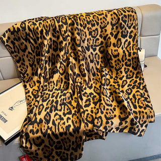 Leopard print blanket draped over a couch with a visible brand tag.