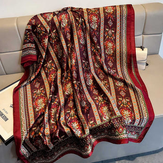 Decorative blanket with intricate patterns on a light-colored sofa.