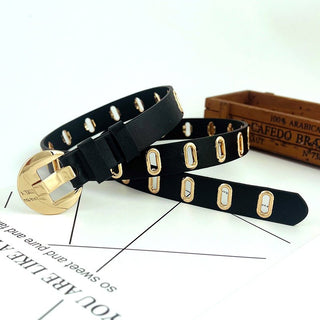 Black leather belt with gold hardware on a white surface