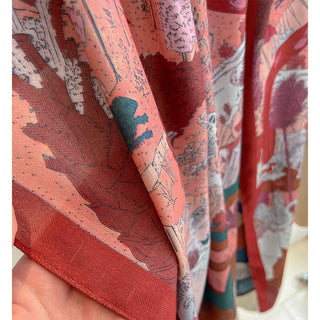 Close-up of a fabric with a colorful pattern, featuring red, pink, and multicolor design.