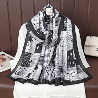 Black and white patterned scarf draped over a white shirt with a brown background