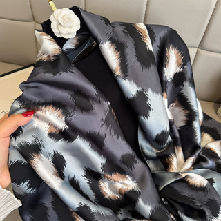 Black and white patterned fabric held by a hand on a beige sofa background
