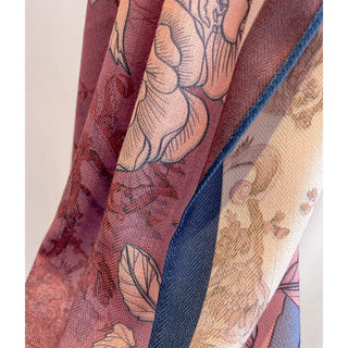 Close-up of a fabric with floral patterns in shades of red, blue, and beige.