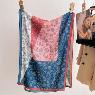 Colorful patterned fabric hanging on a rack with a beige coat and photo frame in the background.