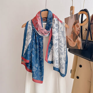 Colorful scarf on a hanger with a coat and handbag in the background