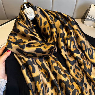 Leopard print scarf held by a hand with a blurred background