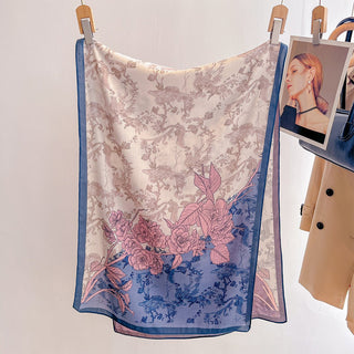 Floral patterned scarf hanging on a rack with a neutral background