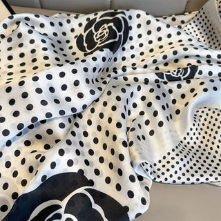 Black and white polka dot fabric with floral patterns on a neutral background