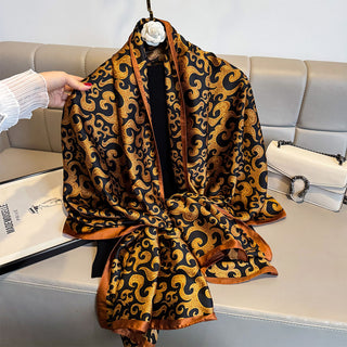 Patterned scarf draped over a chair with a handbag and magazine in the background