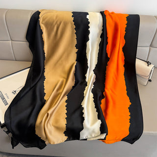 Colorful striped blanket draped over a chair with a neutral background