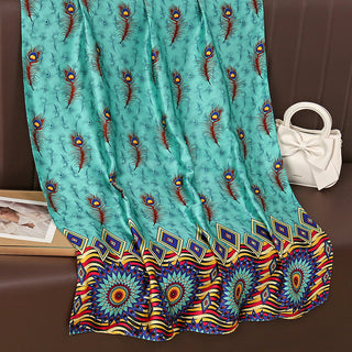 Turquoise fabric with peacock feather pattern on a brown surface